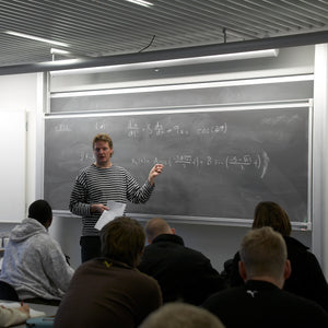 A teacher uses the Presentation Spaces Chalk Column Board to teach math, engaging students who take notes and listen attentively.