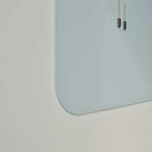 Minimal light blue wall clock and Chameleon Curve frameless whiteboard with rounded corners on white wall, highlighting modern office décor.