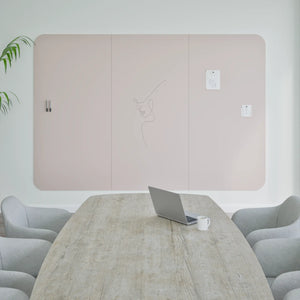 Modern minimalist meeting room with Chameleon Curve Frameless VES Magnetic Whiteboard, wood table, gray chairs, and decor.