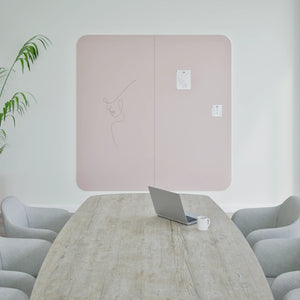 Modern meeting room with wooden table, gray chairs, laptop, Chameleon Curve Wall whiteboard for notes; stylish and minimalist.