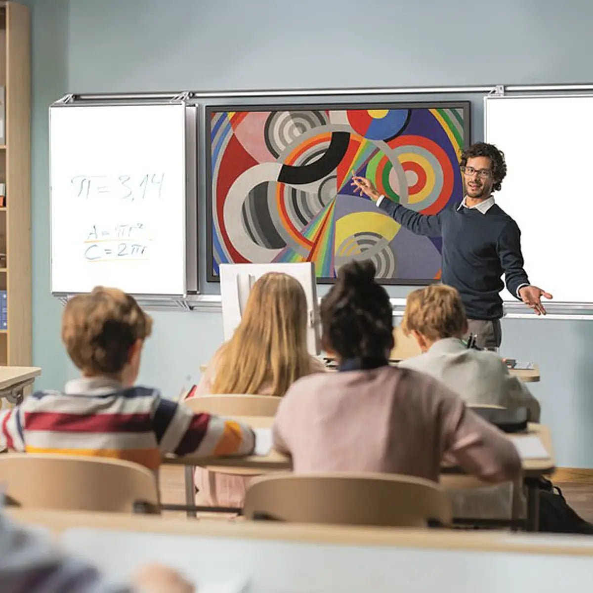 Teacher presents to students using Remonta FlexiView Slider boards—space-saving, interactive touchscreen and dry-wipe surfaces.