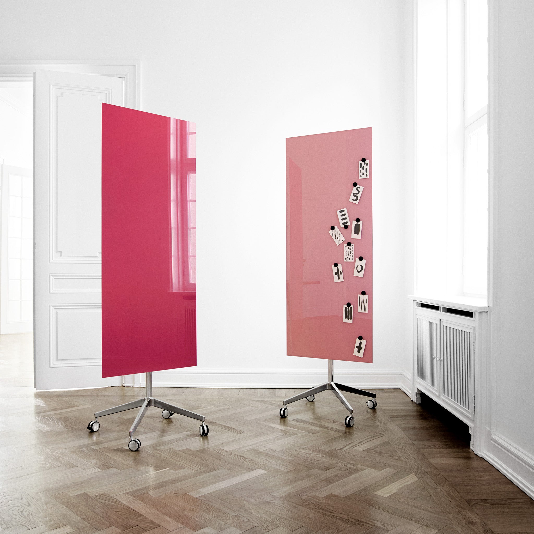 Showcase your ideas with two pink Lintex Mood Mobile glass boards on wheels in a bright room—ideal for product presentations.