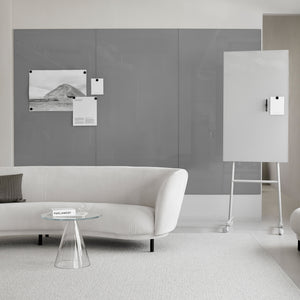 Modern minimalist office with Lintex Mood Spaces magnetic glass board, white sofa, glass table, and mobile whiteboard on carpet.