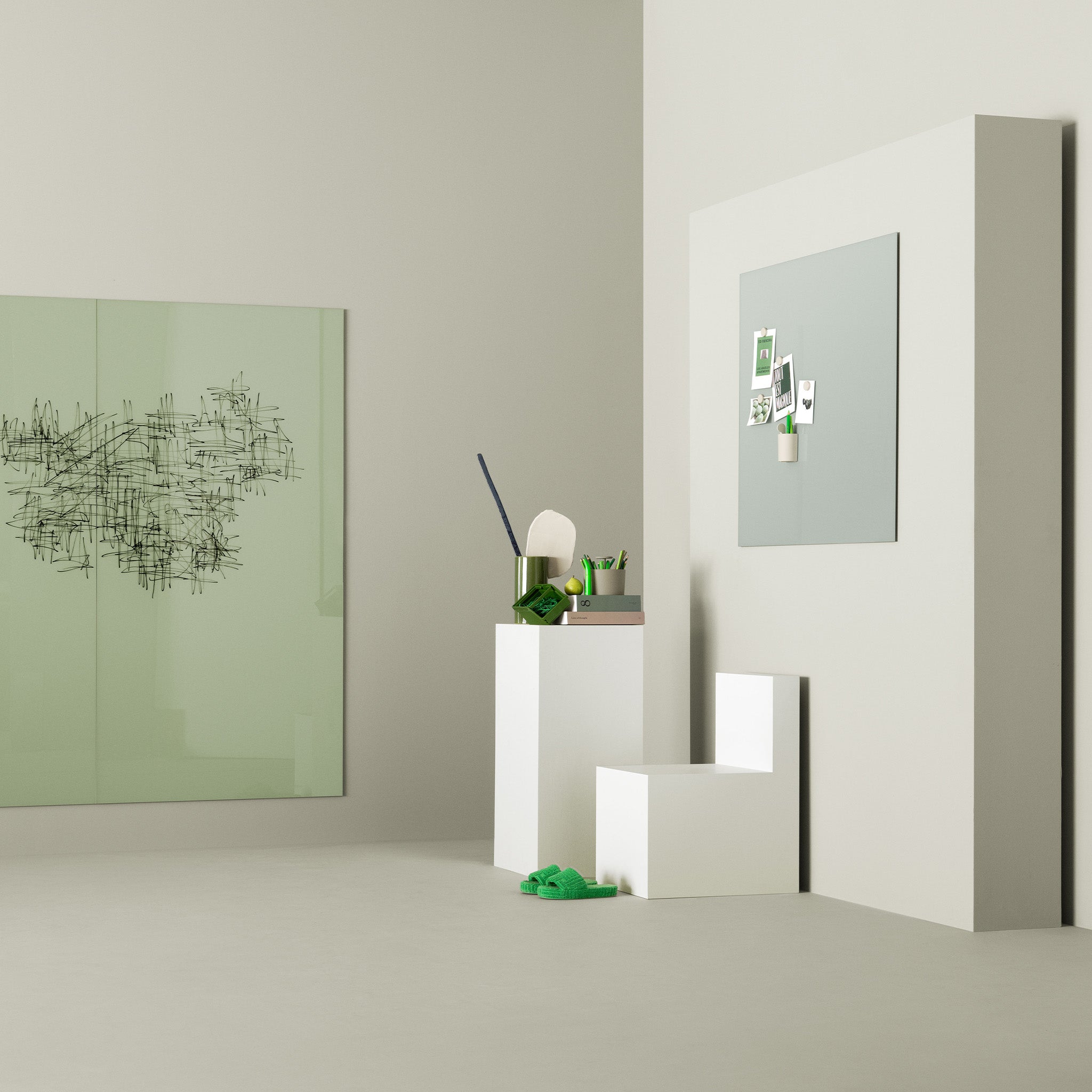 Minimalist room with pale walls, Lintex Mood Wall magnetic board, white geometric chair, green decor, and stylish green slippers.