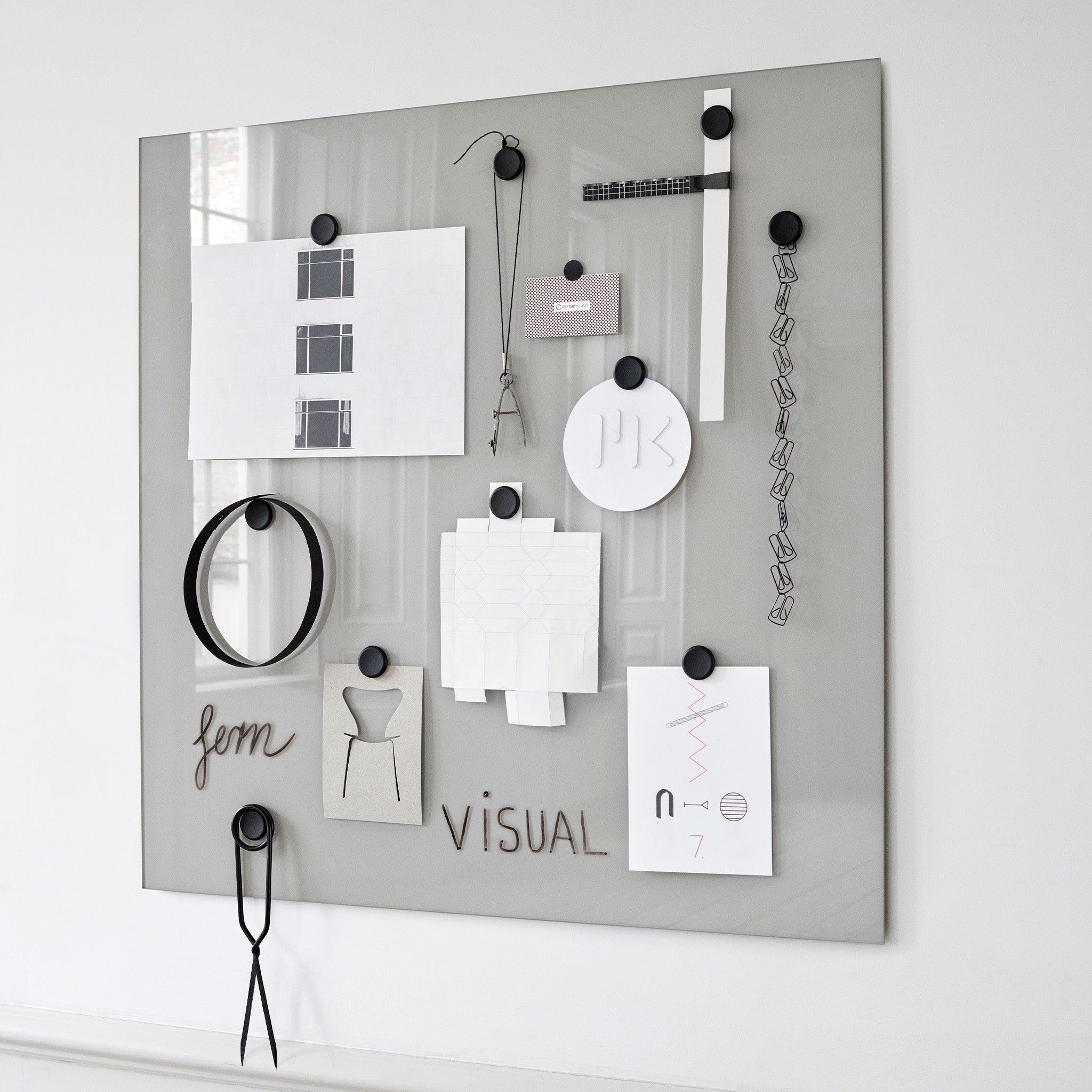 Showcasing the Lintex Mood Wall: a sleek gray magnetic glass board with black magnets. Available in 24 vibrant colors.