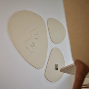 Elevate any space with Chameleon's Chameleon Pebbles VES Magnetic Whiteboard—abstract beige art, minimalist face, modern decor.