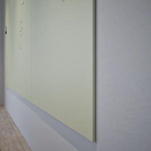 Modern minimalist room with light wood floor, Chameleon Sharp Wall frameless magnetic whiteboard glowing in natural light.
