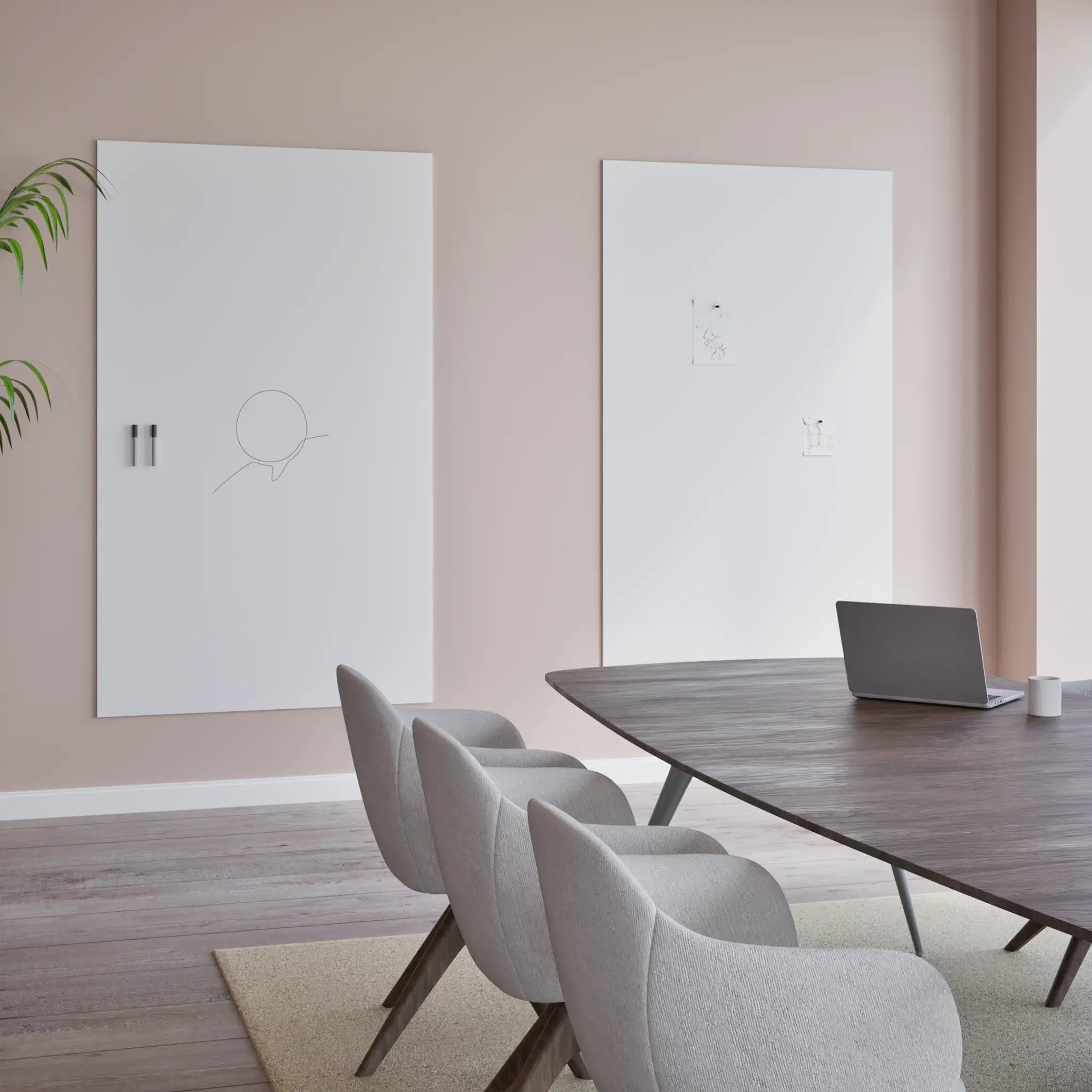 Modern conference room with four chairs, oval table, laptop, and two Chameleon VES Magnetic Whiteboards on a light pink wall.