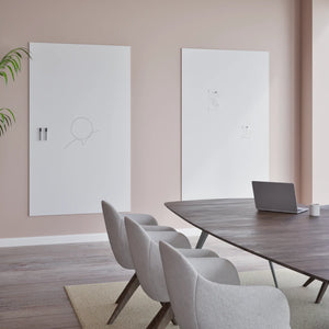 Modern conference room with four chairs, oval table, laptop, and two Chameleon VES Magnetic Whiteboards on a light pink wall.