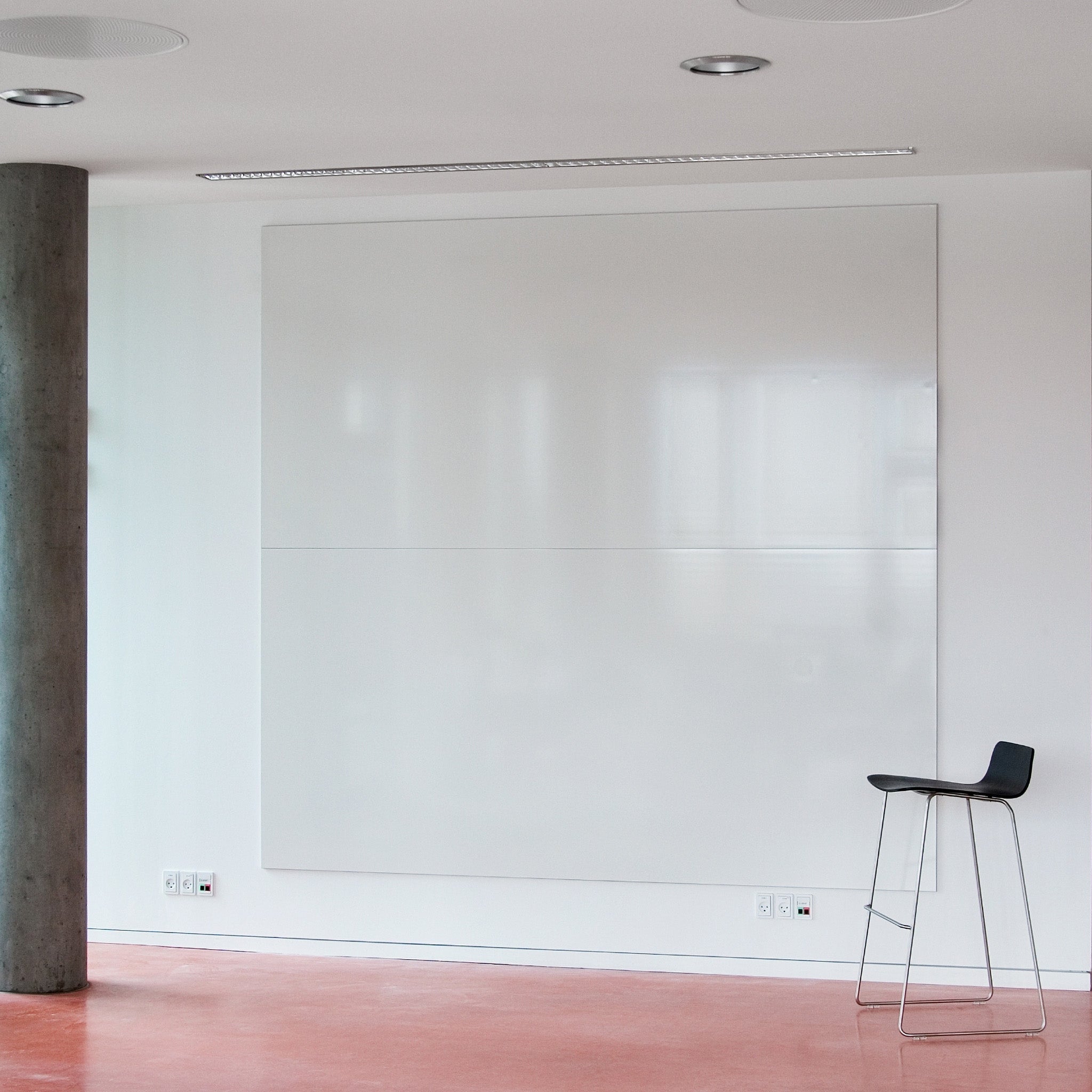 Showcasing the Chalk Continuous Unframed Writing Wall by Presentation Spaces in a sleek modern room with red floors and stylish seating.
