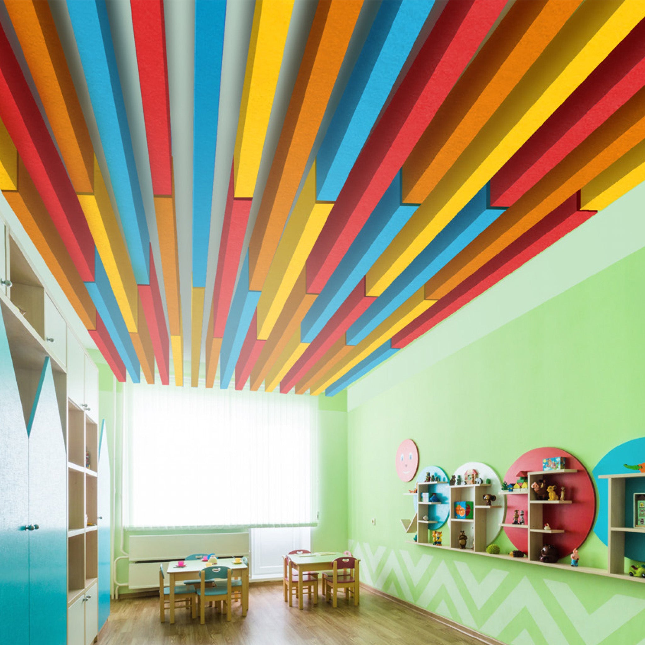 Vibrant classroom with green walls, kid-sized tables, Zen Zone Baffle acoustic panels, and sunlight pouring through large windows.