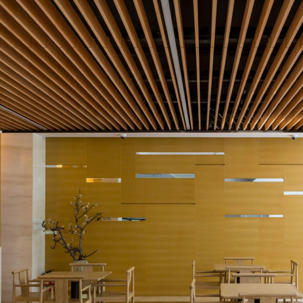 Modern dining area with wood tables, yellow cutout walls, stylish décor, and Zen Beam acoustic baffles for optimal sound control.