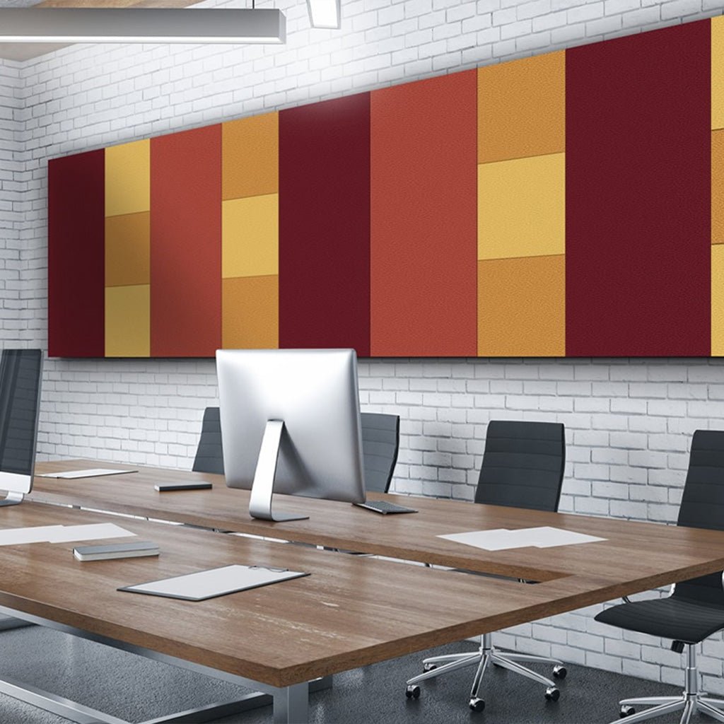 Modern conference room with wood table, black chairs, monitor, and Zen Zone Zen Liner acoustic panels in red, orange, and yellow.