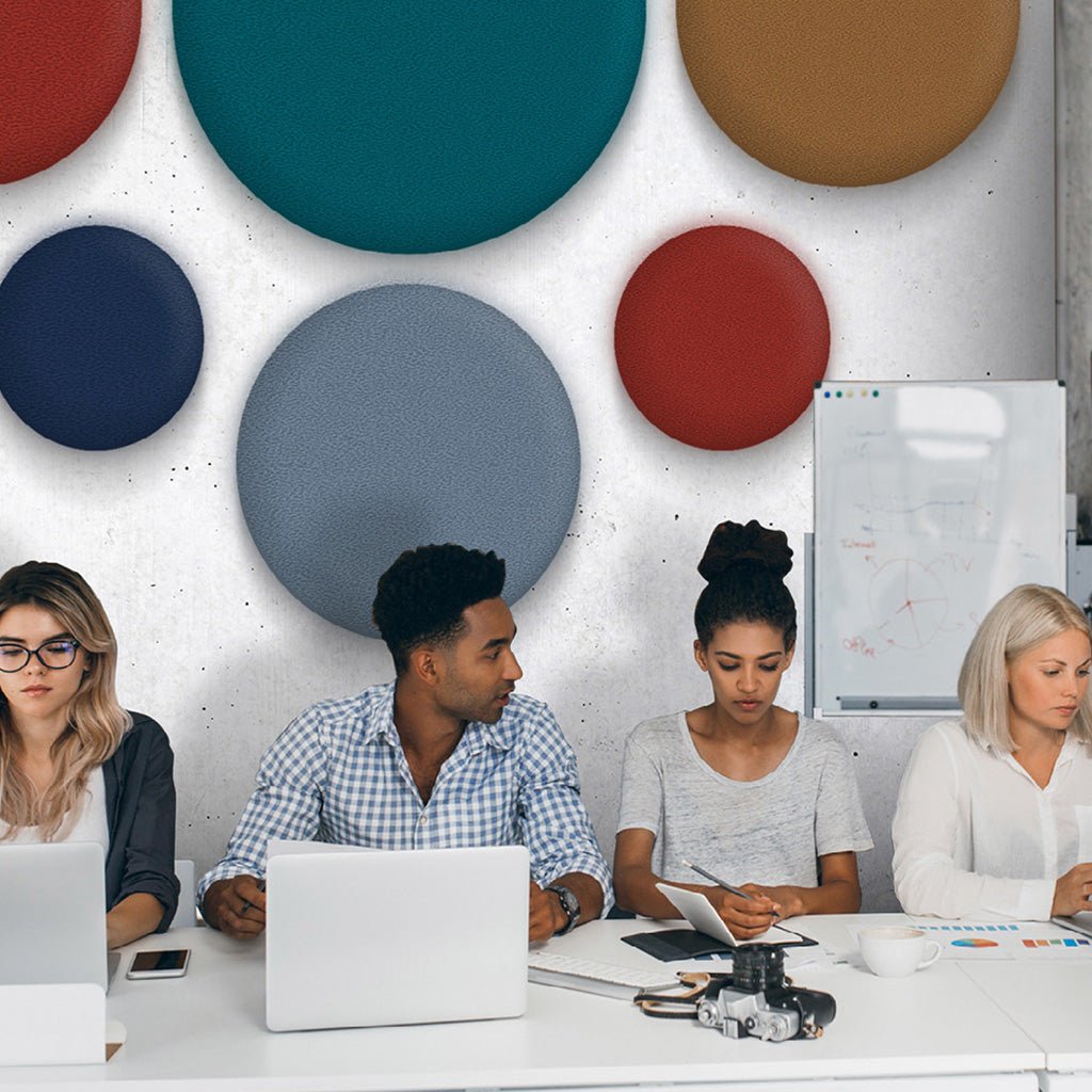 Modern office team collaborates at table with laptops; Zen Pearl wall panels and whiteboard enhance color, acoustics, productivity.