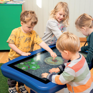 Children engaged with Presentation Spaces Interactive Mobile PlayPanel 32" touchscreen, enjoying a colorful digital nature game.