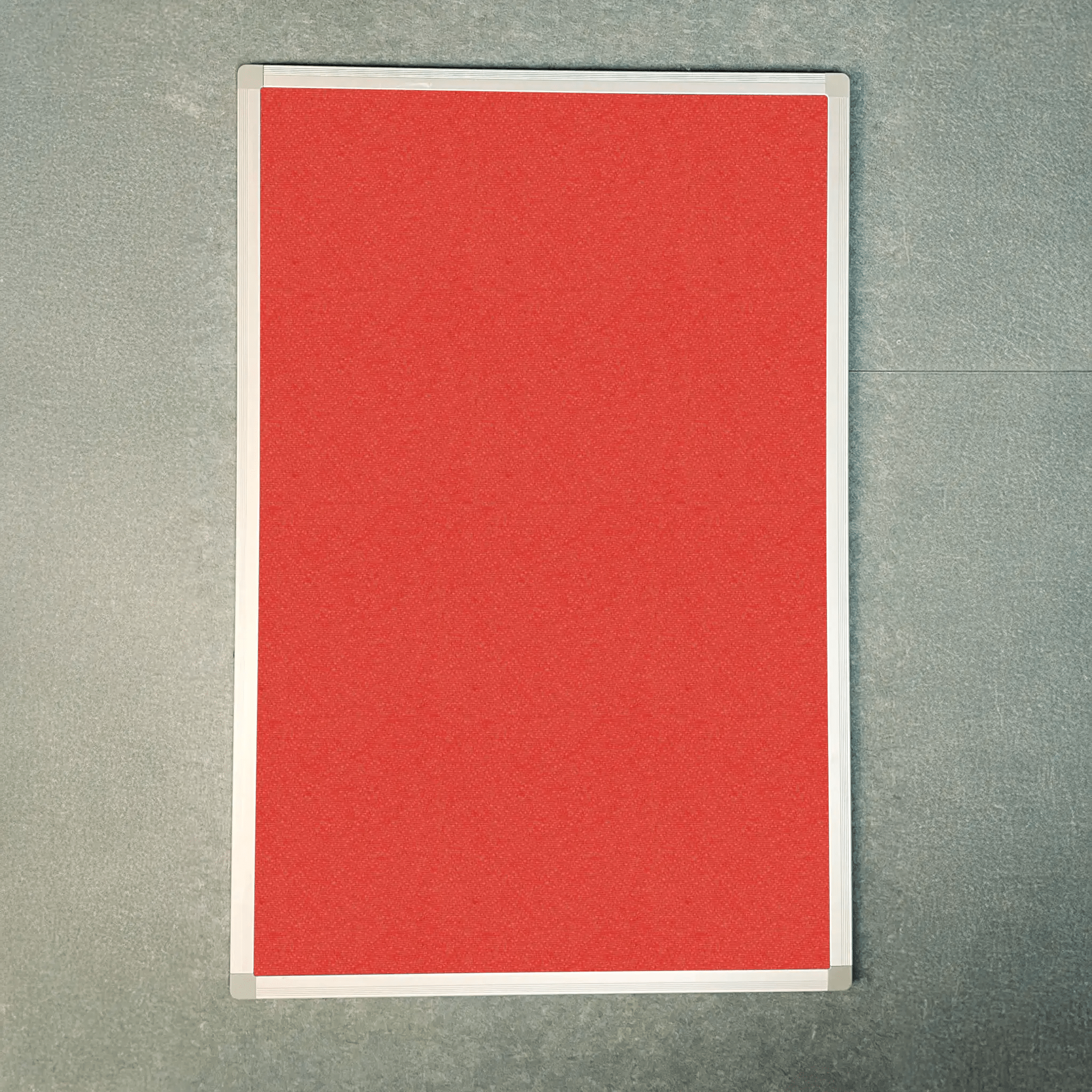 Premier Camira Lucia Aluminium Framed Notice Board with red display, white border, Class 1 fire rating; top view on gray surface.